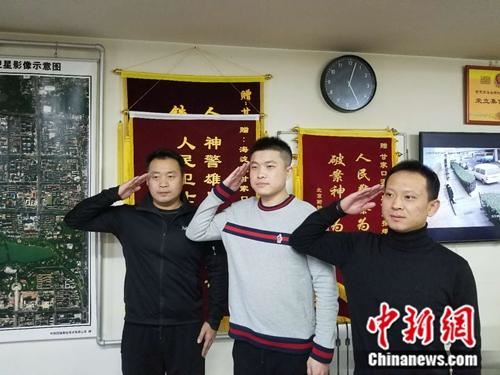 三位民警重现当天“对监控敬礼”的情形。左起：李克、乔宇、刘志远。 冷昊阳 摄