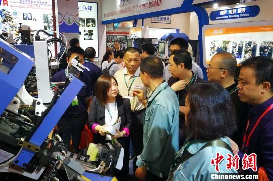 小巧精细、技术先进的台湾鞋机一直颇受业界青睐。图为参观者聆听台湾诚锋机械销售人员讲解最新设备。　孙虹 摄